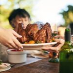 Thanksgiving,,Turkey,And,Hands,With,A,Family,Eating,A,Meal