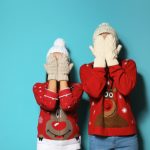 Young,Couple,In,Christmas,Sweaters,And,Knitted,Hats,On,Color
